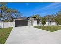 Beautiful home with black trimmed windows and a black garage door surrounded by a freshly cut lawn at 6302 N 39Th St, Tampa, FL 33610