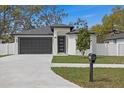 Charming home features a modern front door, well-manicured lawn, and a spacious two-car garage at 6302 N 39Th St, Tampa, FL 33610
