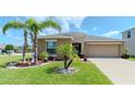 Inviting single-Gathering home featuring lush landscaping and a manicured lawn at 7019 Wiseman Run Dr, Sun City Center, FL 33573