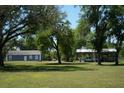 Exterior shot of home with a building and storage in the background at 7040 Lumberton Rd, Zephyrhills, FL 33540