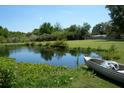 Scenic view of a serene pond near a Mad River Canoe and lush landscaping at 7040 Lumberton Rd, Zephyrhills, FL 33540