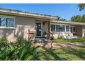 Inviting front porch with seating, plants and manicured landscaping at 7909 Garden N Dr, St Petersburg, FL 33710