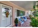Cozy front porch with brick flooring and wicker seating with blue floral pattern cushions at 940 43Rd Ne Ave, St Petersburg, FL 33703