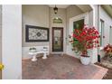 Inviting front porch with a bench, decorative art, and flowering plants at 9897 Sago Point Dr, Seminole, FL 33777