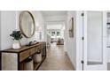 Inviting entryway showcasing a console table with decorative mirror, leading into a bright living space with tile flooring at 10589 Farm Hill Ave, Land O Lakes, FL 34638