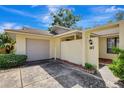 Welcoming home with front courtyard, one car garage, and tropical plants at 107 Parkside Colony Dr, Tarpon Springs, FL 34689