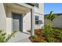 Close-up of the front entrance, featuring lush landscaping and neutral tones at 11022 Moonsail Dr, Parrish, FL 34219