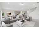 Inviting open-concept living space features neutral tones, modern furnishings, and seamless flow to kitchen and dining at 11022 Moonsail Dr, Parrish, FL 34219