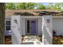 Close-up of the front entrance with a distinctive purple door and decorative lighting at 11368 93Rd St, Largo, FL 33773