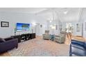 Bright living room with vaulted ceilings and a large TV, creating a cozy atmosphere at 11368 93Rd St, Largo, FL 33773