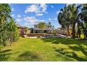 Expansive backyard with a lush lawn, brick retaining wall, and privacy fence, perfect for outdoor activities at 12525 Sparkleberry Rd, Tampa, FL 33626