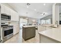 Bright kitchen features white cabinets, stainless steel appliances, and a center island at 1318 Crimson Clover Ln, Wesley Chapel, FL 33543