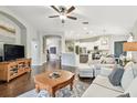 Spacious open-concept living room with wood floors and seamless transition to the kitchen at 1318 Crimson Clover Ln, Wesley Chapel, FL 33543