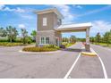 View of community gate house entrance with manicured landscaping on a bright sunny day at 16633 Mooner Plank Cir, Wimauma, FL 33598