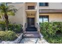 Close-up of front door with charming details and access to a welcoming condo featuring verdant landscaping at 2205 Belleair Rd # A24, Clearwater, FL 33764