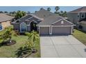 Well-maintained single Gathering home featuring a spacious driveway and a beautiful lawn at 2310 Wood Pointe Dr, Holiday, FL 34691