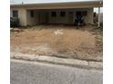 Modest single-story home with gravel yard and covered parking showing front entrance at 249 144Th Ave, Madeira Beach, FL 33708