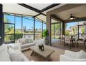 Bright sunroom with pond view features comfortable seating and a dining area for relaxing or entertaining guests at 3219 Gianna Way, Land O Lakes, FL 34638