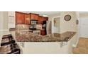 Open kitchen featuring granite countertops, stainless steel appliances, and cherry cabinets at 4002 Crockers Lake Blvd # 1-128, Sarasota, FL 34238