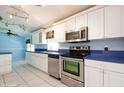Bright kitchen featuring white cabinetry, stainless steel appliances, and tiled flooring at 472 Trout Ln, Oldsmar, FL 34677