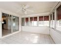 Spacious sunroom with tile flooring, ceiling fan, and access to the kitchen at 472 Trout Ln, Oldsmar, FL 34677