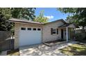 Side view of a cozy brick home featuring an attached garage and lush greenery at 4824 16Th St, Zephyrhills, FL 33542