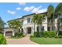 Beautiful home featuring a well-manicured lawn, a circular driveway, and a two-car garage at 5025 W Homer Ave, Tampa, FL 33629