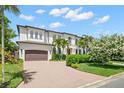 Spacious home featuring a two-car garage, a circular driveway, and mature landscaping at 5025 W Homer Ave, Tampa, FL 33629