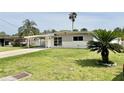 Single-story home with a carport and landscaped yard; a cozy suburban retreat at 5043 Osprey Ln, New Port Richey, FL 34652