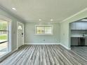 Bright living room with new gray flooring, fresh paint, and ample natural light at 5043 Osprey Ln, New Port Richey, FL 34652