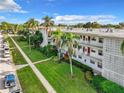 Beautifully maintained condo building featuring mature palm trees and lush green lawn at 5150 10Th N Ave # 302, St Petersburg, FL 33710