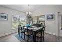 Bright dining room with a large window, stylish chandelier, and an elegant black table set for six at 5938 164Th E Ave, Parrish, FL 34219