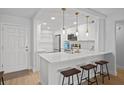 Bright, updated kitchen featuring a large island with bar seating, white cabinets, quartz countertops, and modern stainless steel appliances at 6051 Sun Blvd # 111, St Petersburg, FL 33715