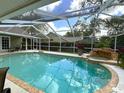 Relaxing screened-in pool area with a waterfall feature and ample space for outdoor seating and entertaining at 6805 Monet Cir, Temple Terrace, FL 33617