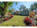 Beautifully landscaped front yard featuring a lush green lawn and striking red ornamental plants enhancing the home's curb appeal at 7311 N Dartmouth Ave, Tampa, FL 33604