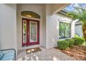 Elegant front door with decorative glass and a 'welcome' mat on a brick porch at 8248 Sequester Loop, Land O Lakes, FL 34637