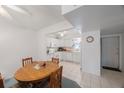 Dining area with an adjacent view into a white kitchen at 9945 47Th Ave N # 203, St Petersburg, FL 33708