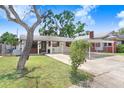 Charming single-story home featuring a covered carport and a well-maintained front yard on a sunny day at 1054 13Th S Ave, St Petersburg, FL 33705