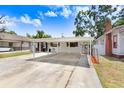 Charming single-story home featuring a covered carport and a well-maintained front yard on a sunny day at 1054 13Th S Ave, St Petersburg, FL 33705