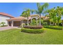 Beautiful home with a well-maintained lawn and sculpted landscaping, complemented by mature palm trees at 1819 Bella Casa Ct, Tampa, FL 33618
