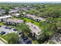 Scenic aerial view of a condo community with lush greenery, trees, and ample parking at 2400 Winding Creek Blvd # 2-201, Clearwater, FL 33761