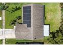 Aerial view showing a home with solar panels on the roof, surrounded by a well-maintained yard and mature trees at 2955 Briar Cliff Dr, Palm Harbor, FL 34684