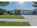 Inviting single-story home featuring a manicured lawn and an elegant double-door entrance at 4693 Aylesford Dr, Palm Harbor, FL 34685