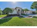 Charming single-story home boasting a lush green lawn and a welcoming double-door entrance at 4693 Aylesford Dr, Palm Harbor, FL 34685