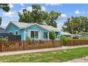 Charming light-blue home with a well-maintained lawn and decorative brown picket fence enhancing the curb appeal at 500 45Th S St, St Petersburg, FL 33711