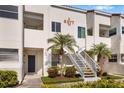 Exterior view of the condo showing stairs, a small front yard with palm trees and garden, and the building number at 6077 Bahia Del Mar Blvd # 125, St Petersburg, FL 33715