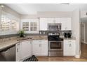 Charming kitchen boasts granite counters, stainless appliances, white cabinetry, and a stylish tile backsplash at 6077 Bahia Del Mar Blvd # 125, St Petersburg, FL 33715