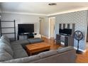 Cozy living room featuring brick accent wall and comfortable seating arrangement at 6221 13Th N Ave, St Petersburg, FL 33710