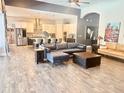 Open-concept living room featuring wood-look tile, modern sofas, and a view of the eat-in kitchen at 6313 Brevada Ln, Apollo Beach, FL 33572