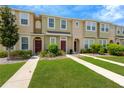 Inviting townhome exteriors with manicured lawns and sidewalks leading to each front door at 7029 White Treetop Pl, Riverview, FL 33578